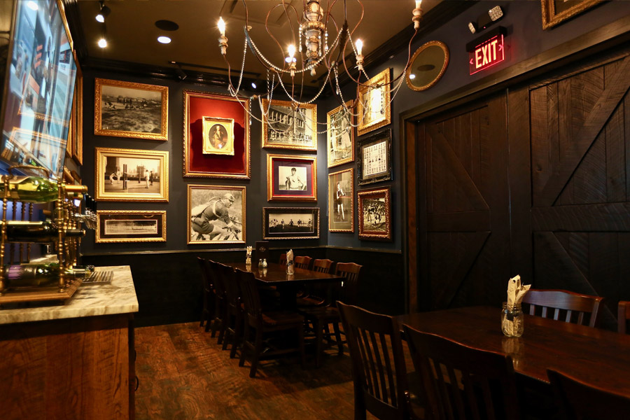 Private dining room with chandelier and pictures on wall.